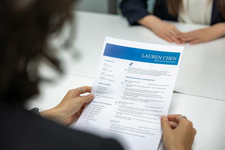 Personne tenant un CV, "resume" en anglais