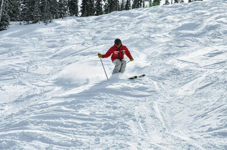 Un skieur en pleine descente sur une piste enneigée