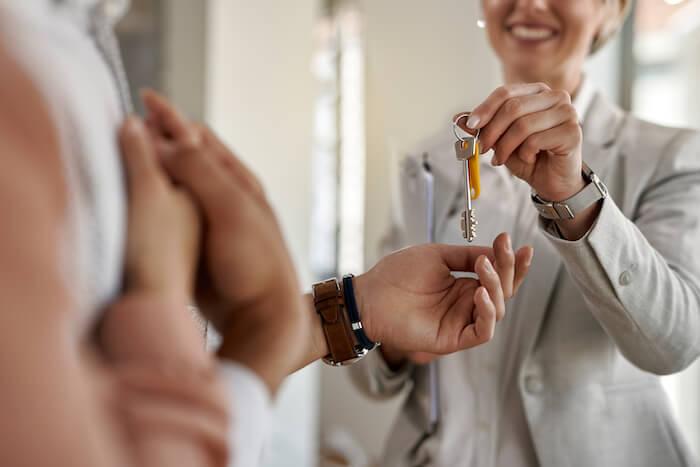 gros plan d'un couple recevant les clés de leur nouvel appartement d'un agent immobilier en Espagne