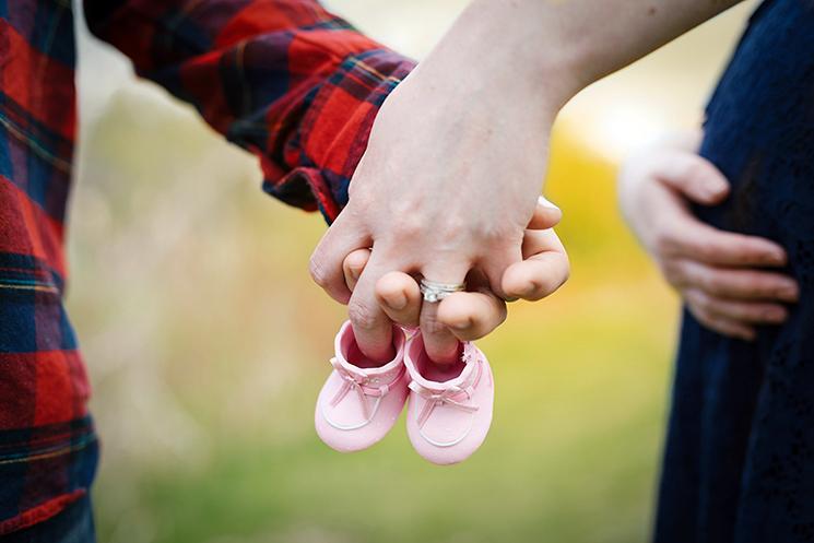 un couple se tient la main avec des chaussures de bébé 