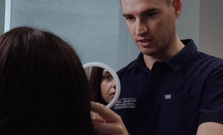 une femme se regarde dans un petit miroir tenu par un médecin